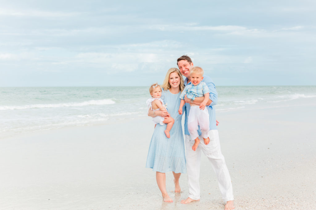 Portrait of family on vacation in Clearwater Beach Florida wearing soft blues and white outfits.